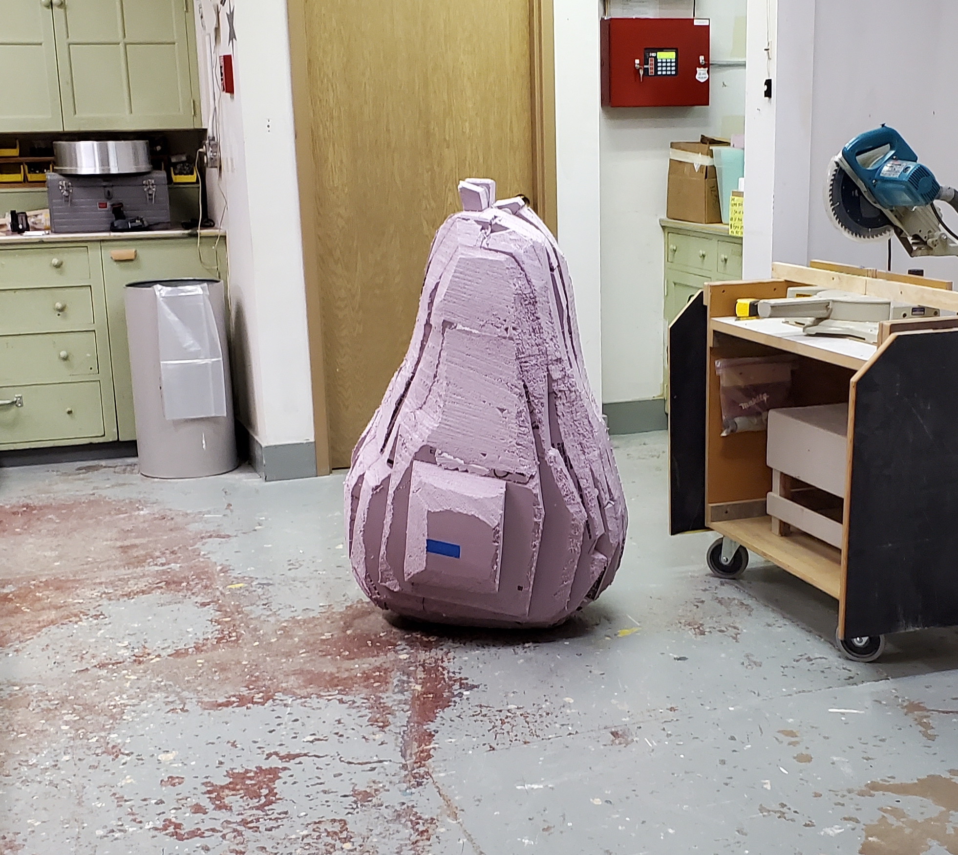 large styrofoam pear sits in a workshop