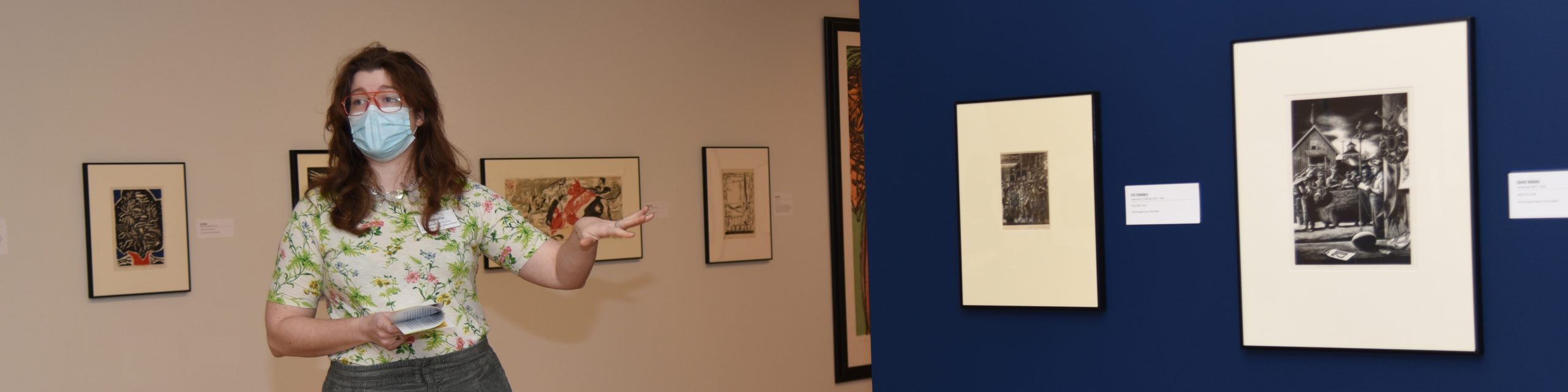 curator pointing to two black and white drawings