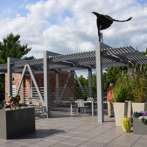 People gather in the Rooftop Sculpture Garden on a sunny day.