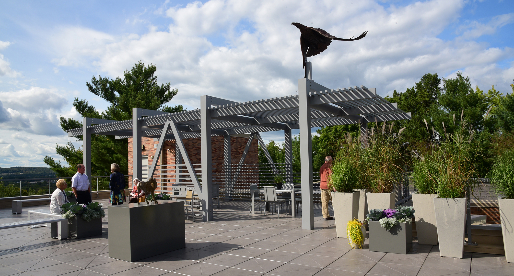 People gather in the Rooftop Sculpture Garden on a sunny day.