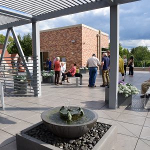 People gather in the Rooftop Sculpture Garden on a sunny day.