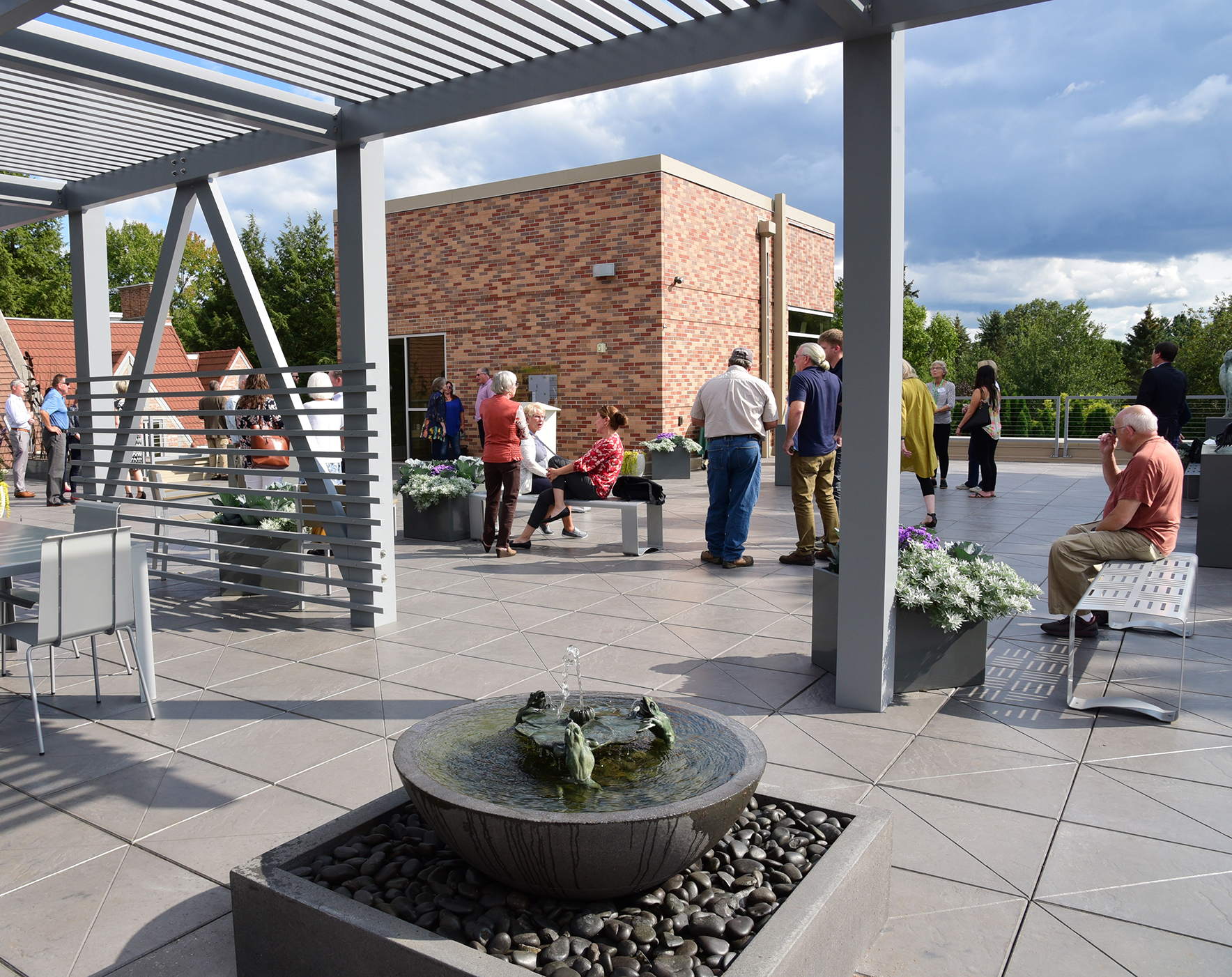 People gather in the Rooftop Sculpture Garden on a sunny day.