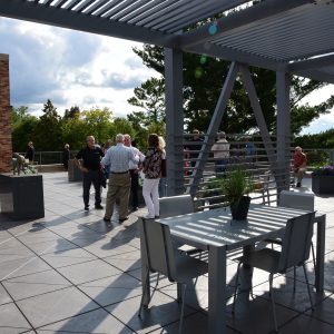 People gather in the Rooftop Sculpture Garden on a sunny day.