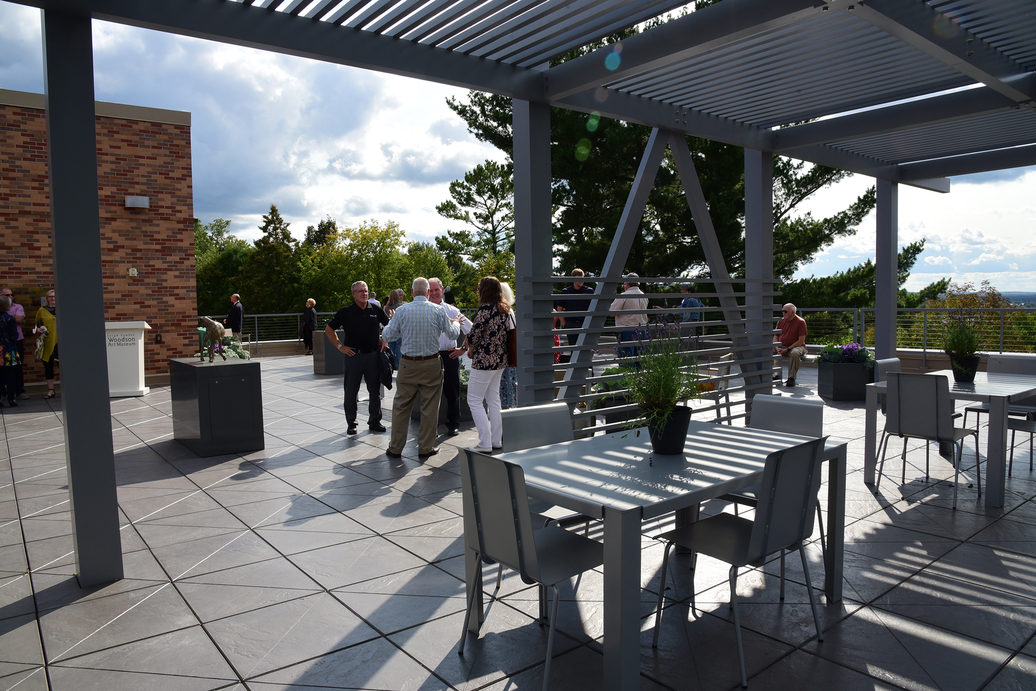 People gather in the Rooftop Sculpture Garden on a sunny day.