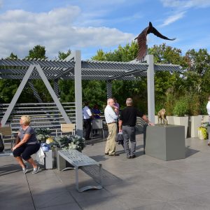 People gather in the Rooftop Sculpture Garden on a sunny day.