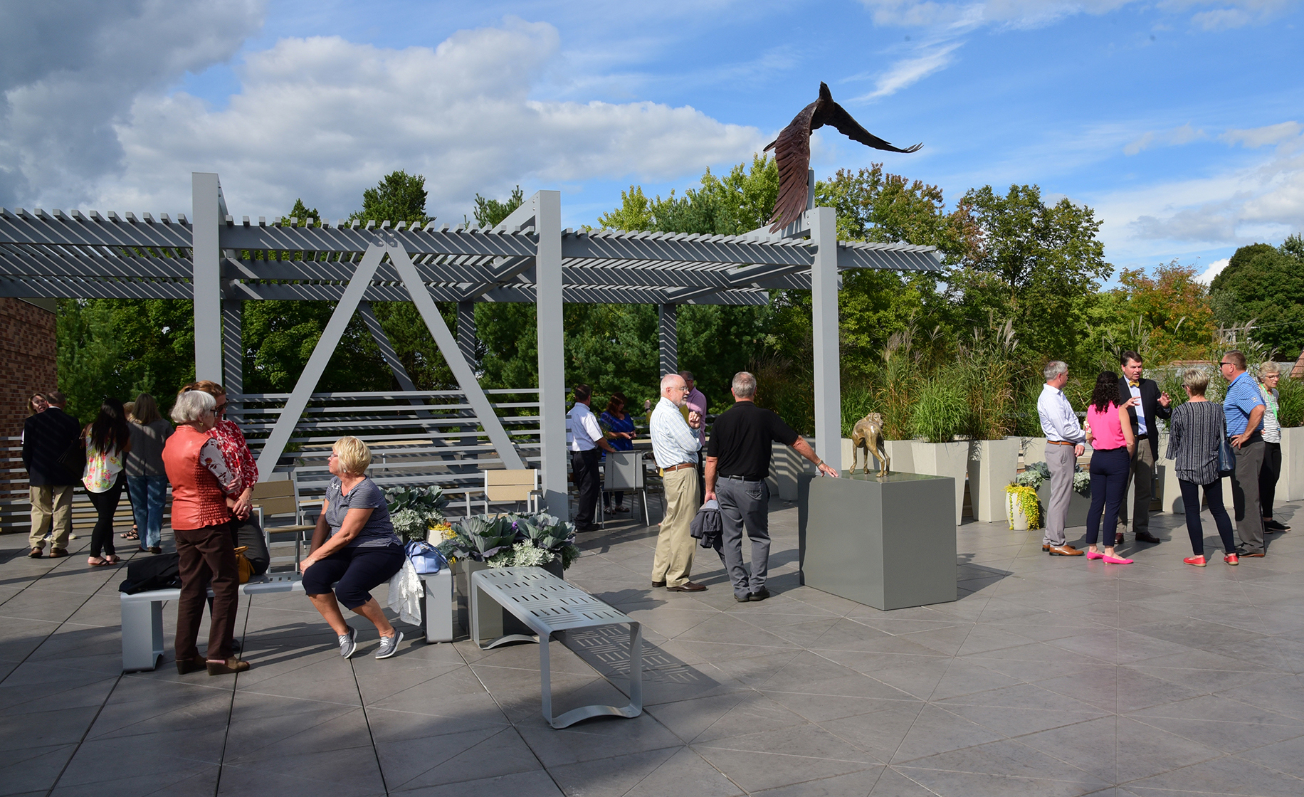 People gather in the Rooftop Sculpture Garden on a sunny day.