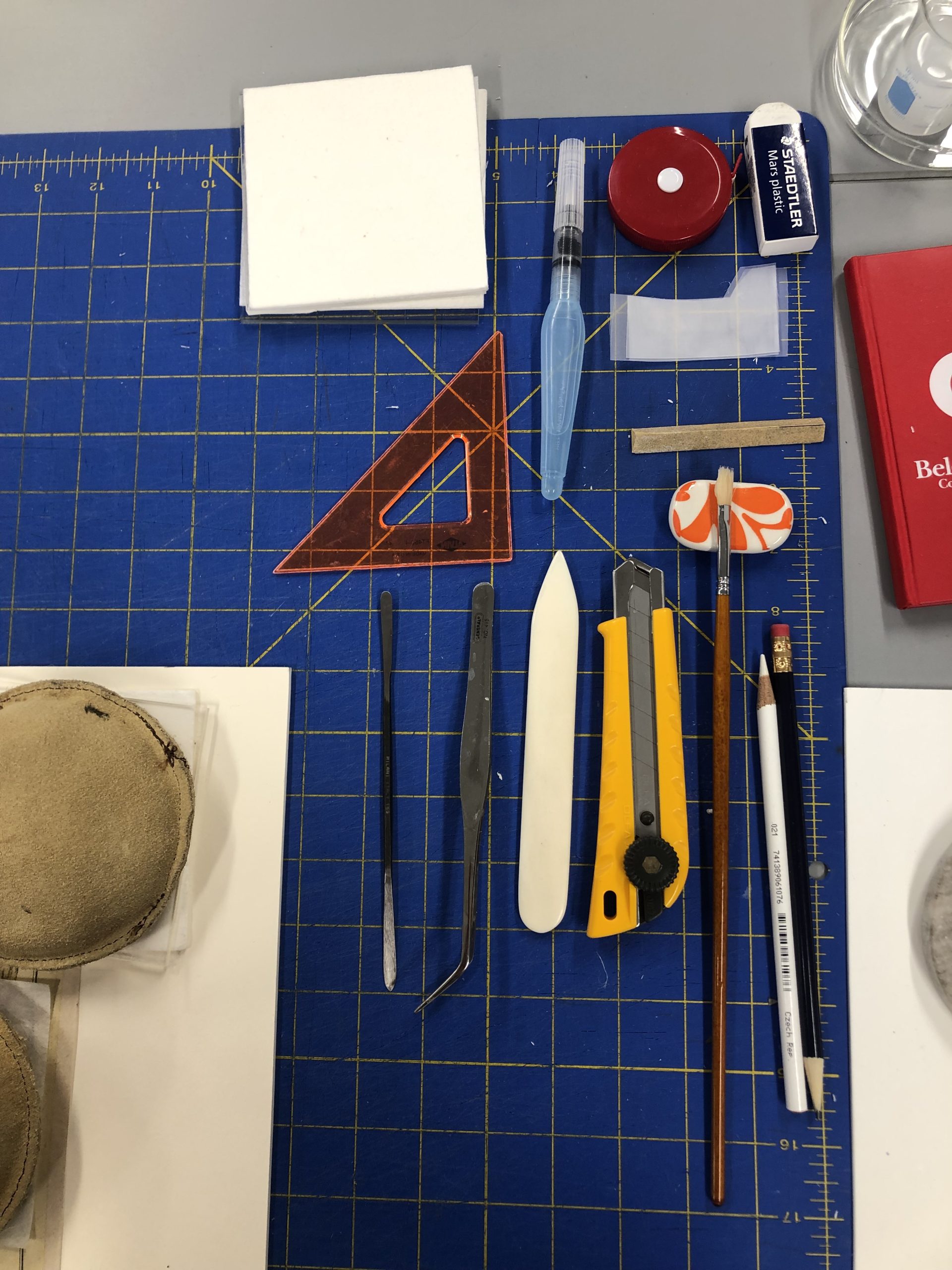 A close-up shot of a different tools on a blue cutting mat.