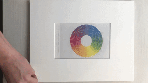 A gif of a color wheel on board being opened to show mat construction. 