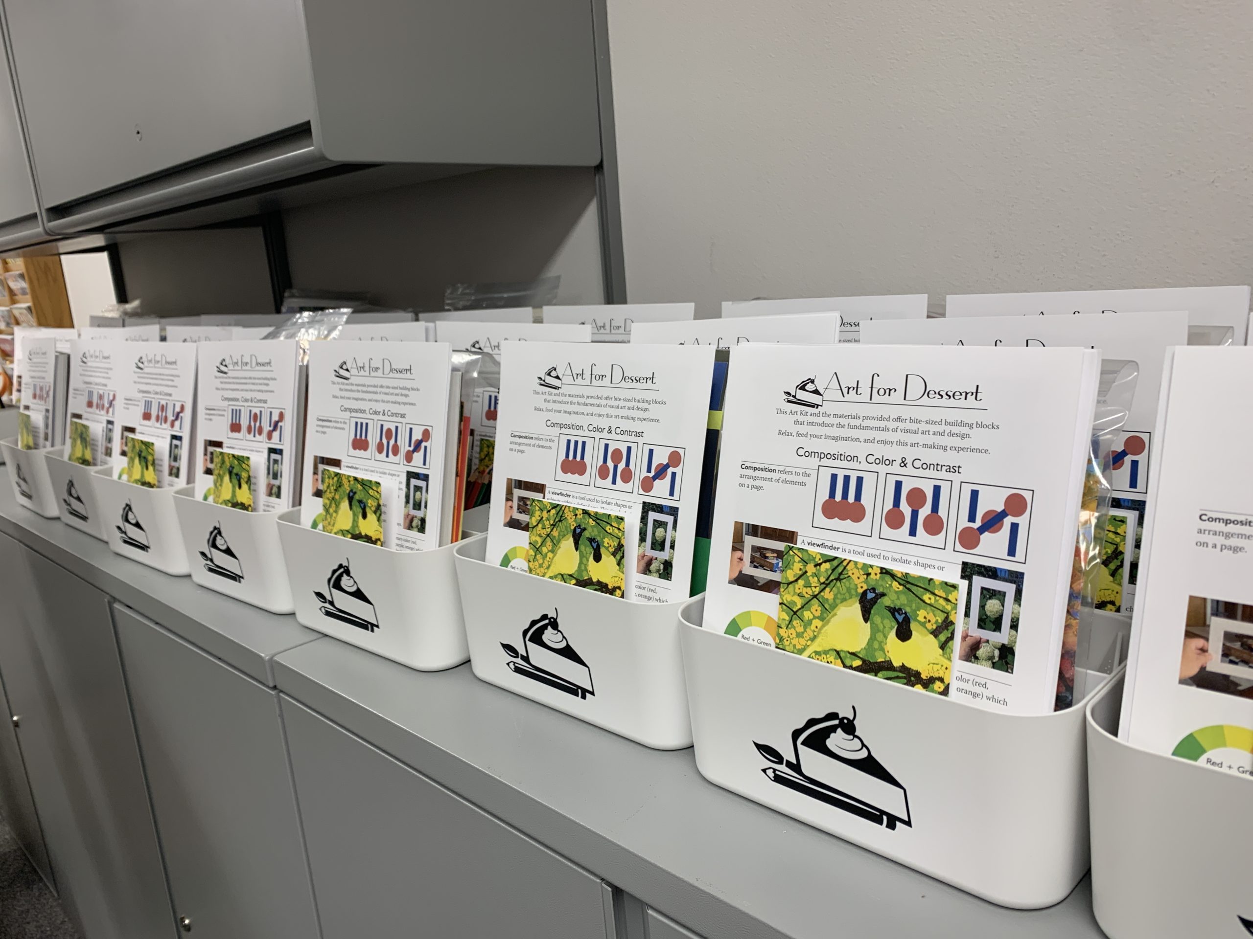 Rows of plastic containers filled with art supplies line the top of a counter in the Museum's workroom. 