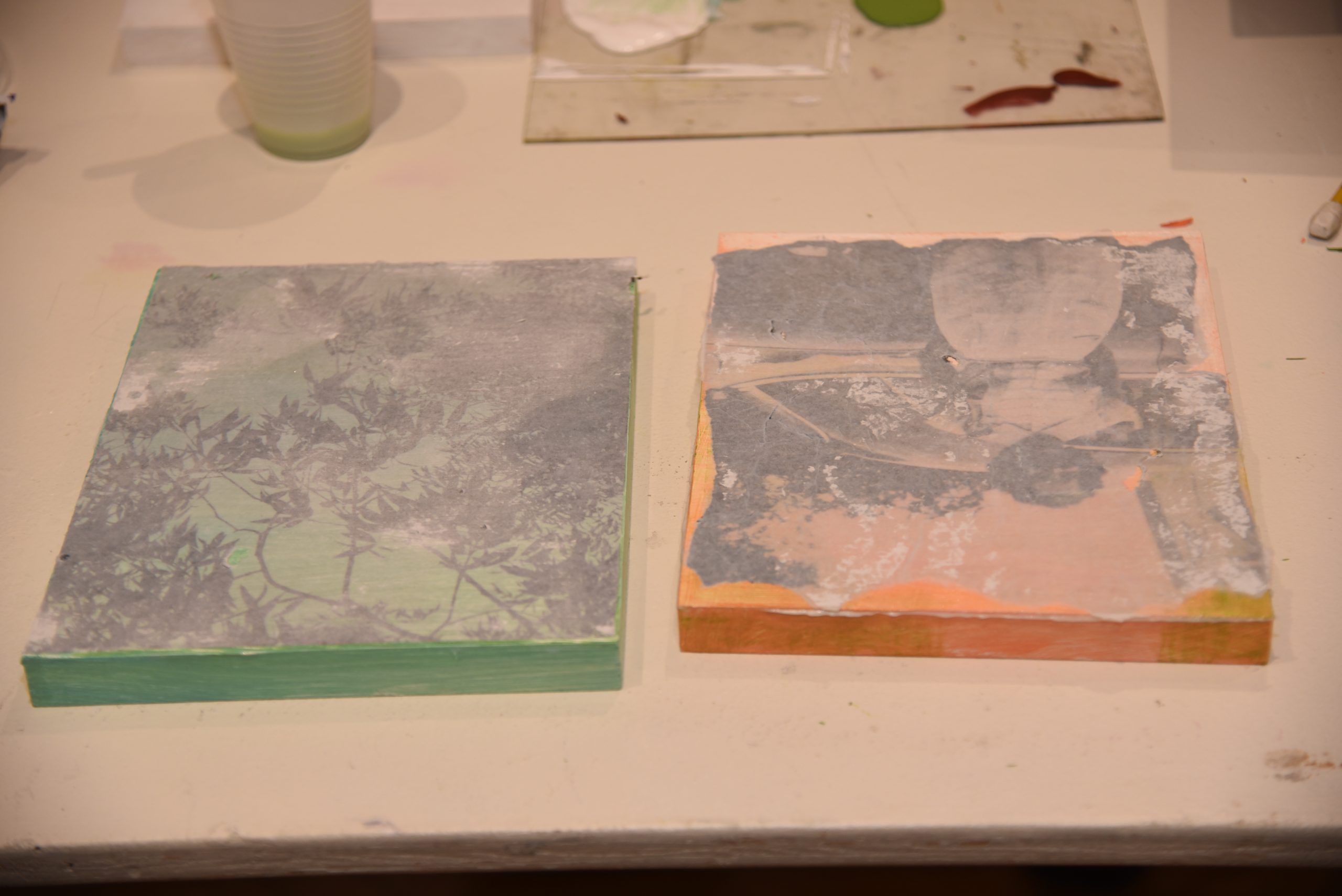 Two images transferred onto panels with green and orange paint 