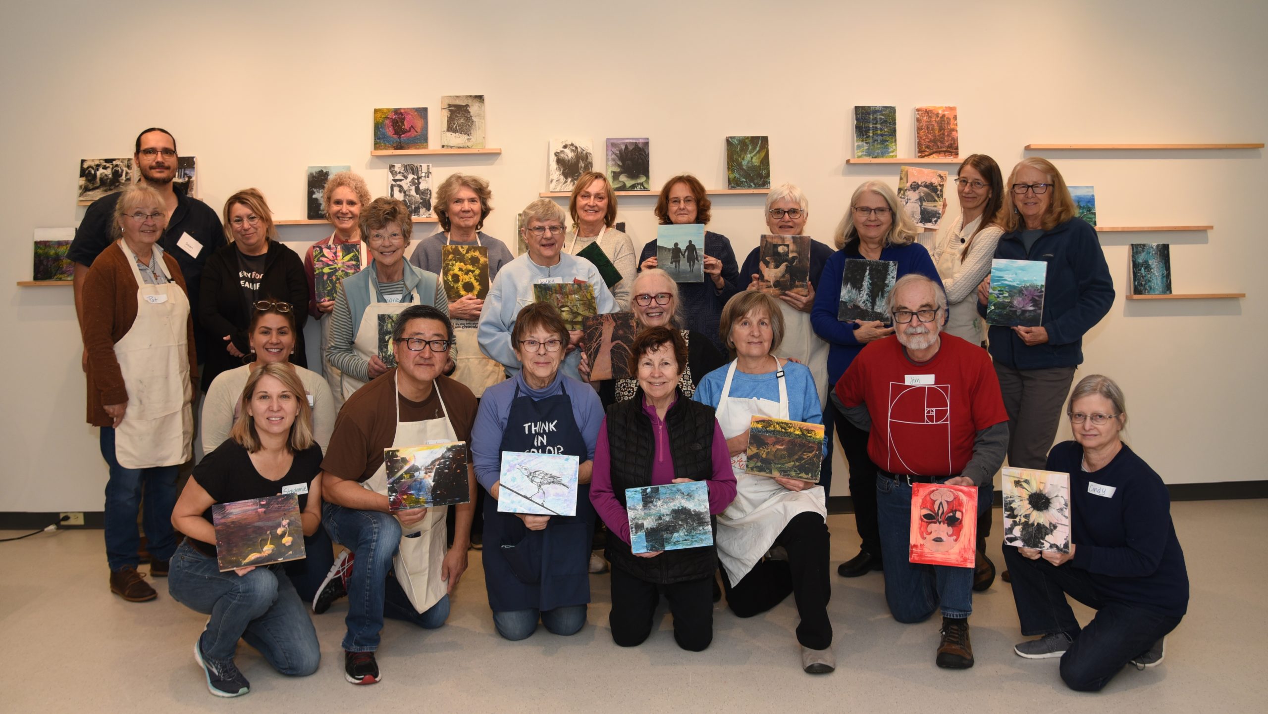 A group photo shows workshop participants with their mixed-media creations