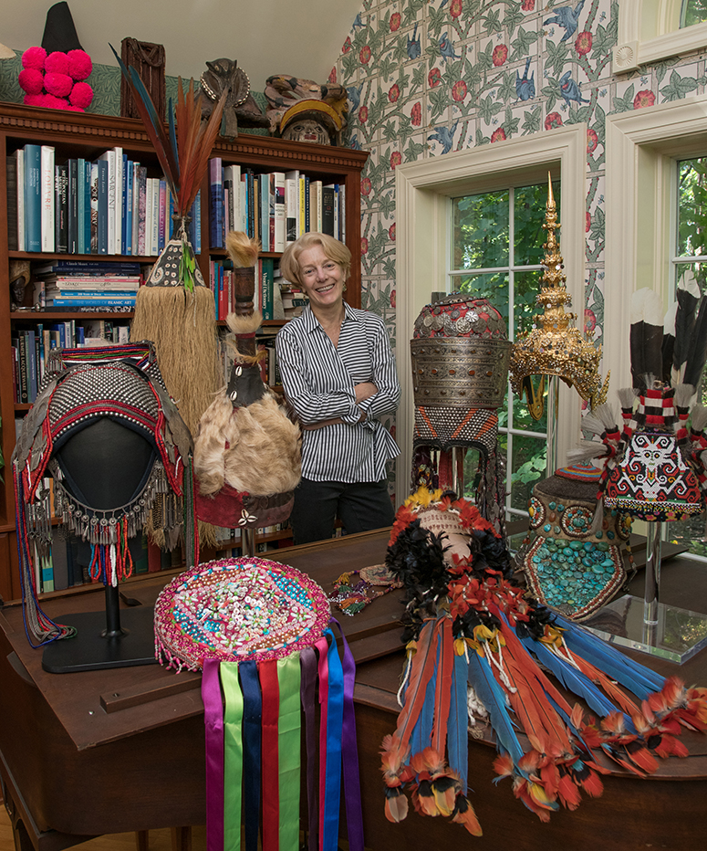 Curator Stacey W. Miller surrounded by hats she's collected throughout the world.