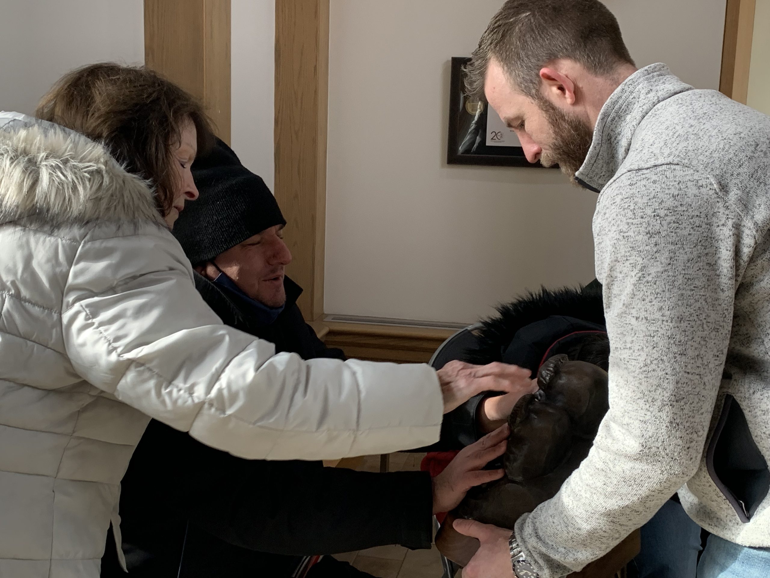 Museum Director Matt Foss holds a bronze sculpture by Team USA Snow Sculptors for Art Beyond Sight participants to touch in the Museum's main entrance.