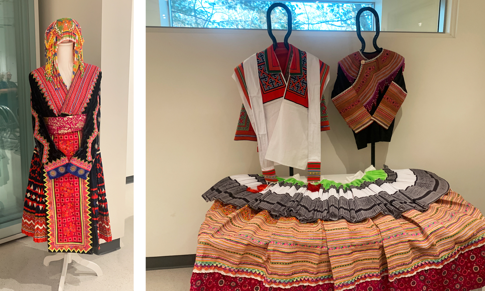 Three Hmong outfits are displayed on mannequins and are adorned with ornate colors, beadwork, and hand-stitched patterns.