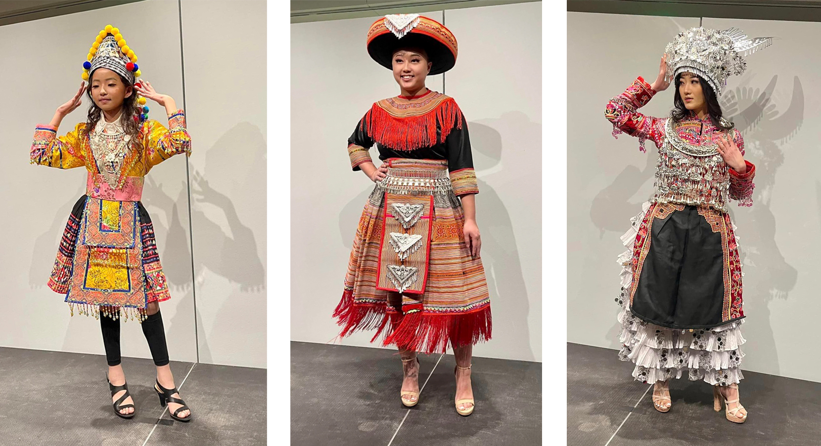 Three models on the runway posing in Hmong outfits