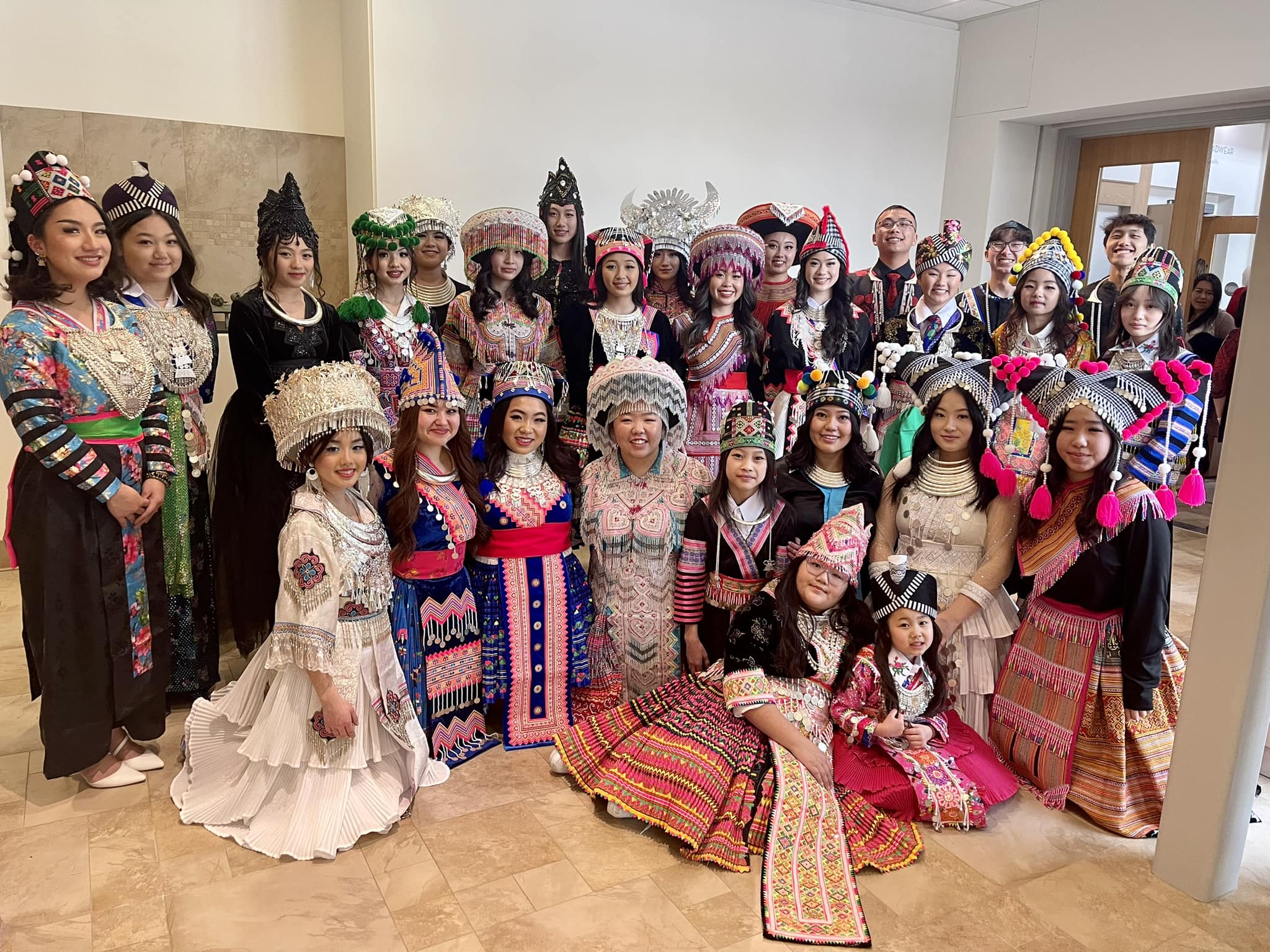 29 volunteer models wearing traditional Hmong clothing with ornate beadwork, colors, and patterns
