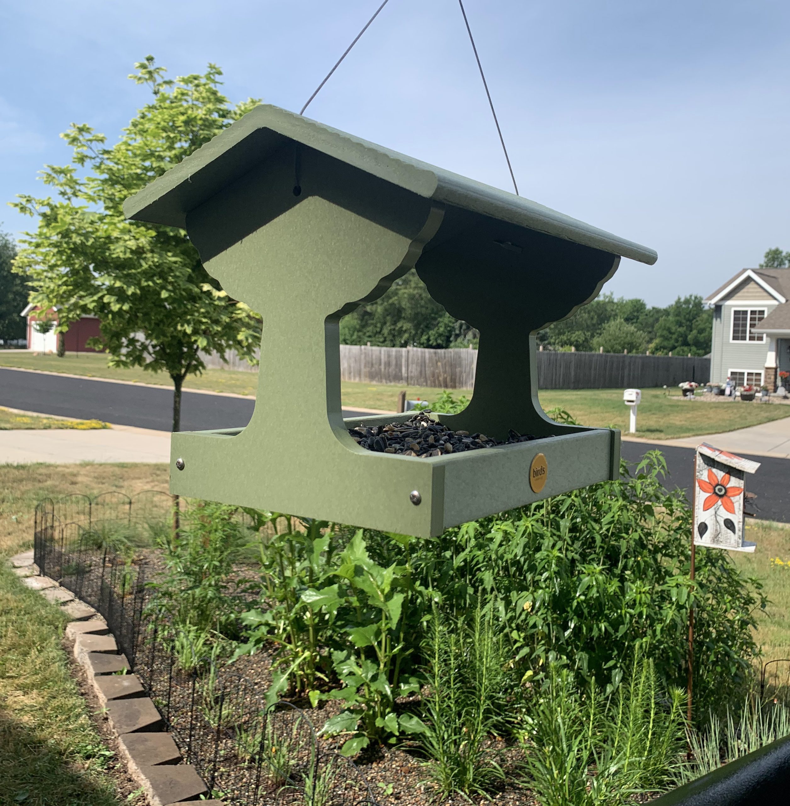 A bird feeder in front of a song bird garden