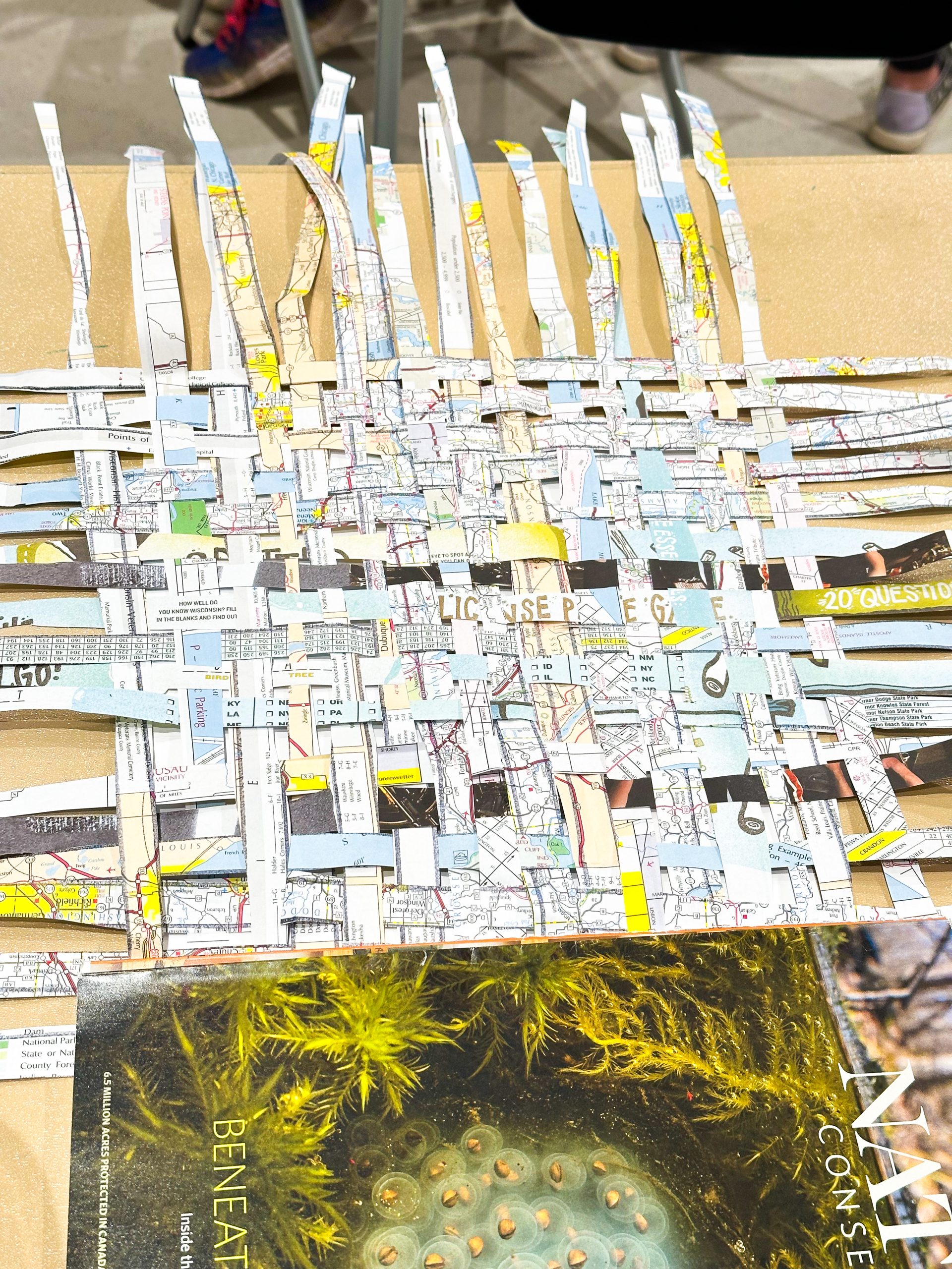 Strips of maps are cut and woven together to create the outside cover of a sketchbook