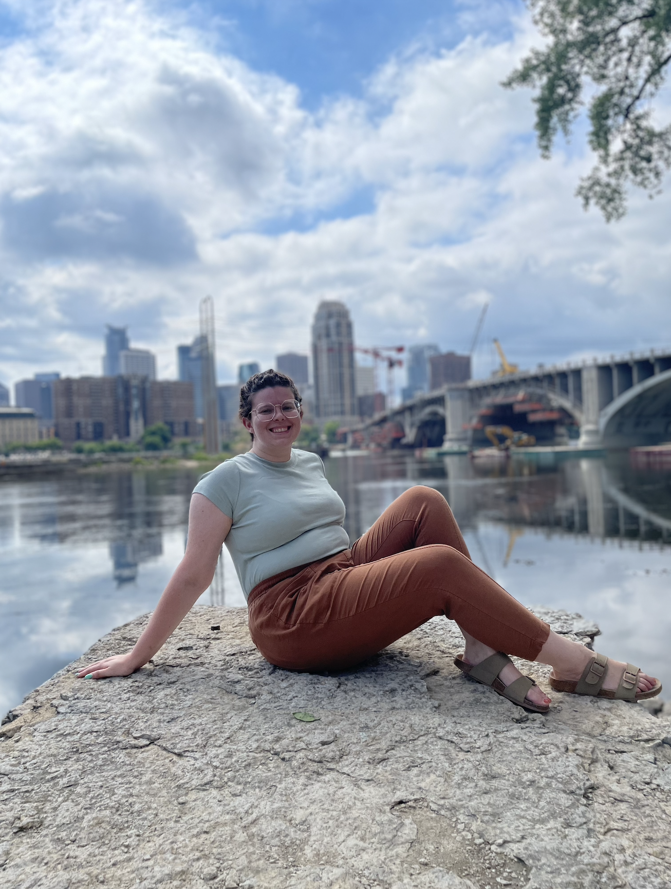Emily Fritz sitting in front of the Minneapolis skyline.