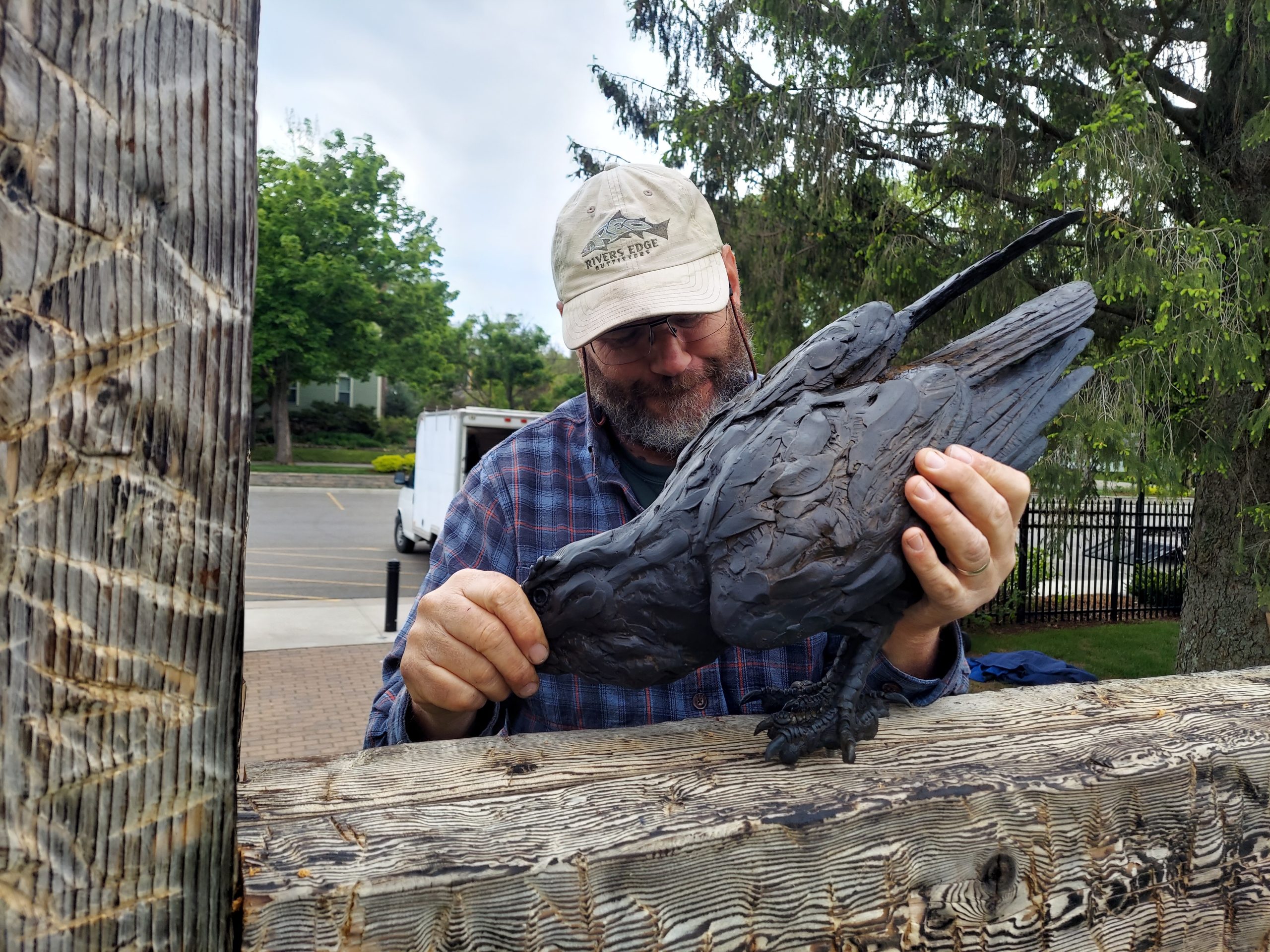 This image shows artist Paul Rhymer as he assembles a sculpture on the Woodson Art Museum grounds