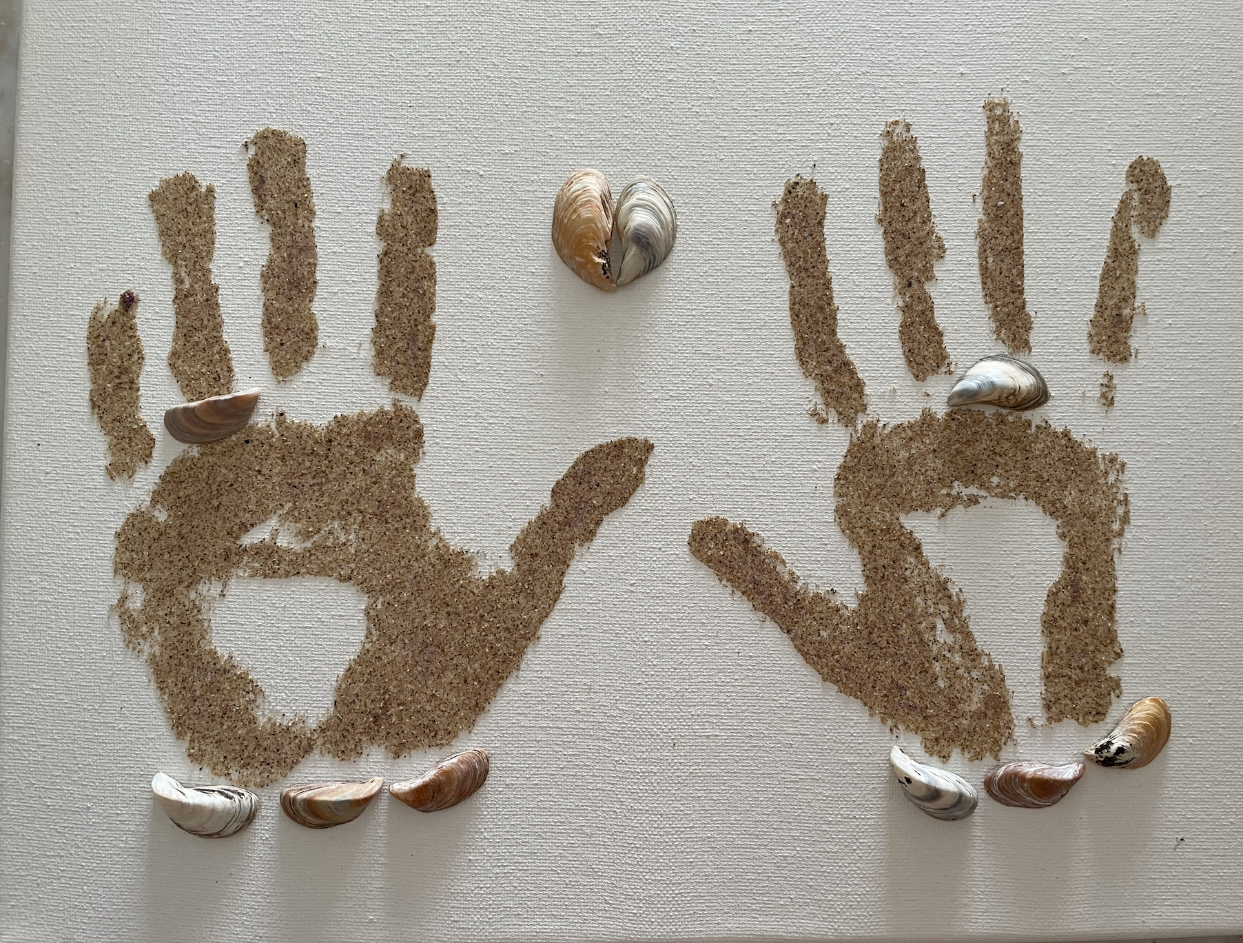 Handprint art made with sand and shells from the beach where we got engaged.
