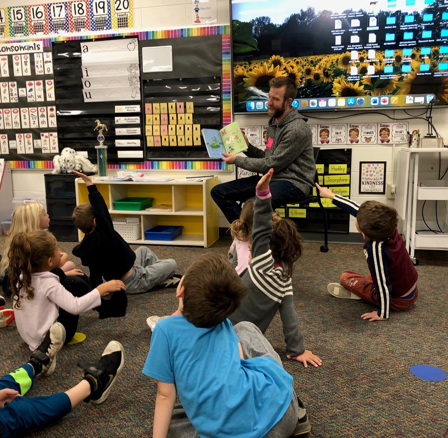 This image shows Museum director Matt Foss reading a book to a group of kindergarteners