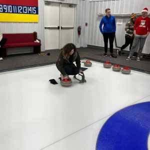 This image shows Curator of Education Emily Fritz preparing to throw a curling stone