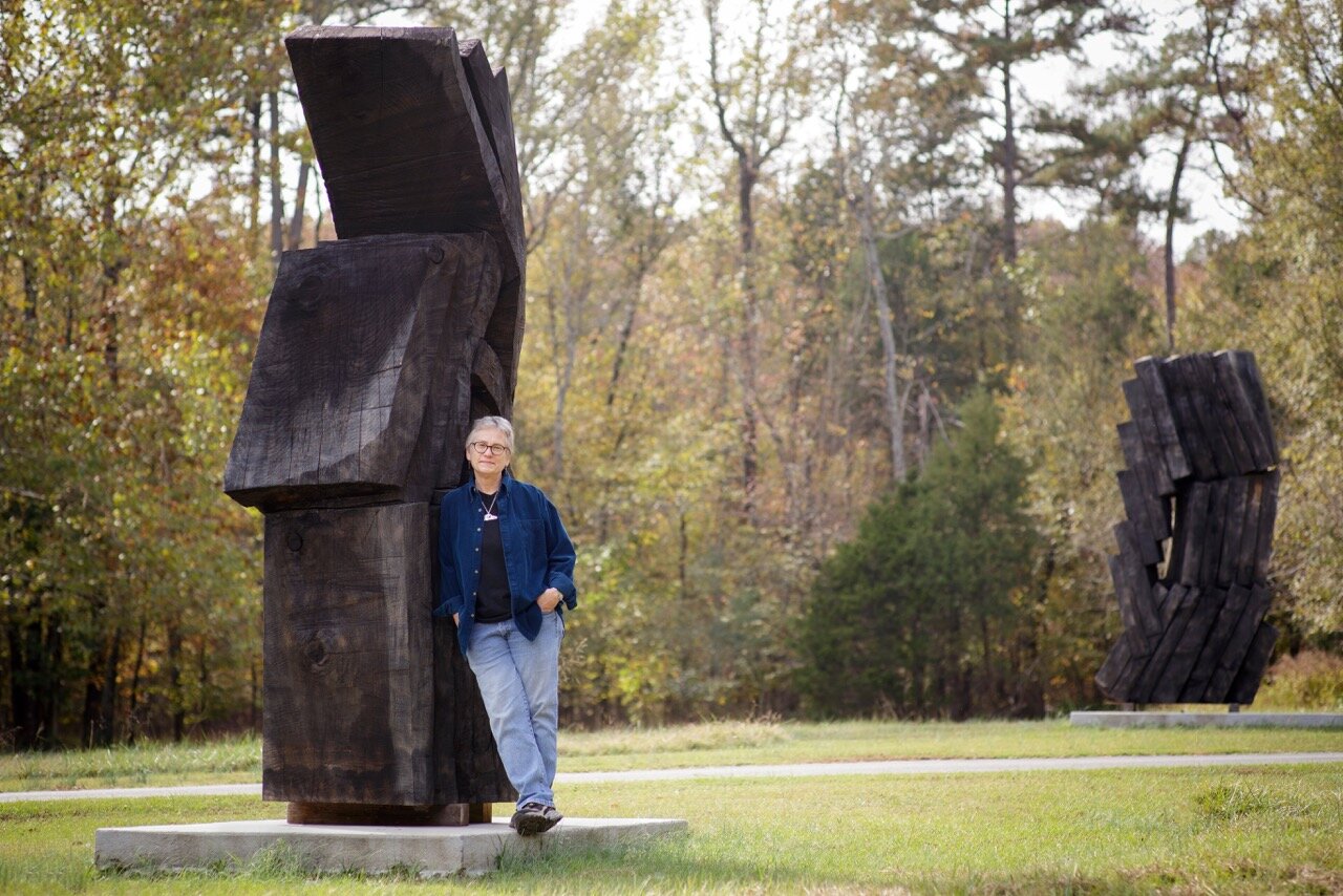 artist robyn Horn standing next to her sculpture that is twice her size