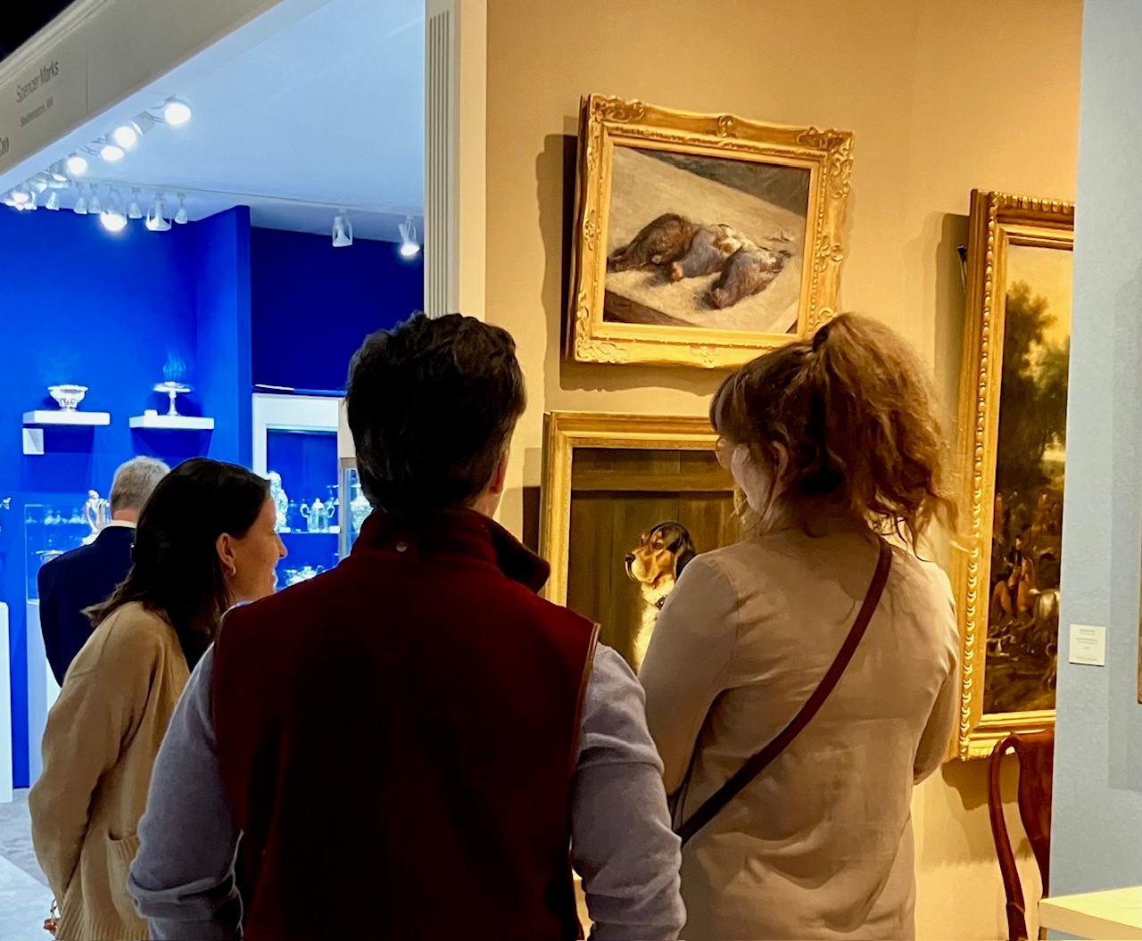 This image shows three people looking at a specific artwork
