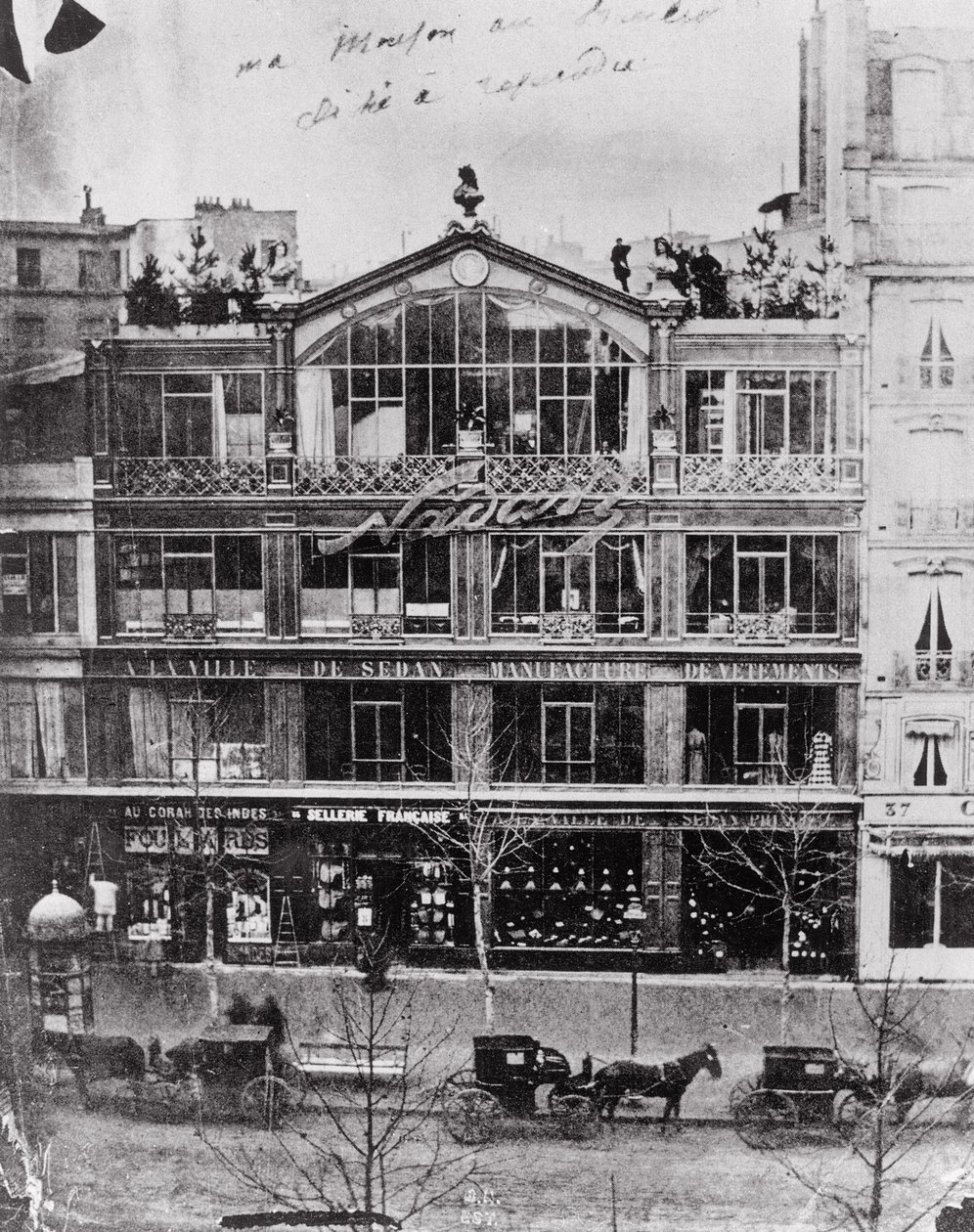 A Parisian storefront with horse and buggy in black and white photograph.