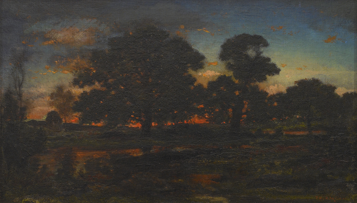 A field with a large tree in front of a bright orange sunset.