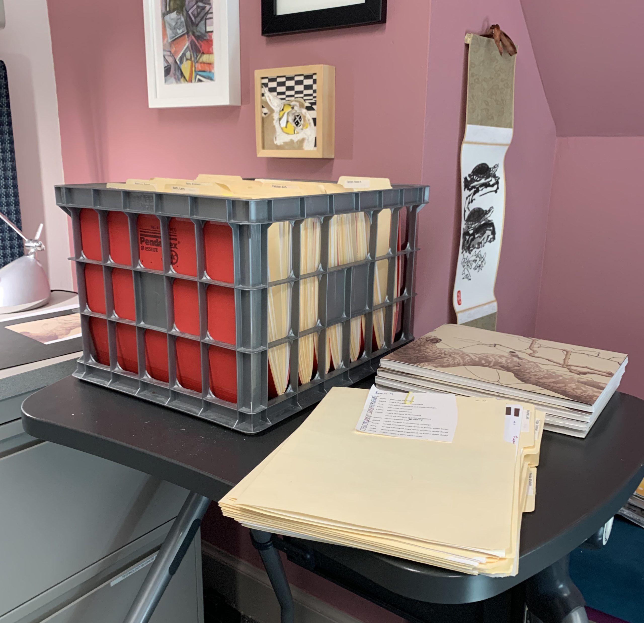 Folders of each artist sit on a table in Elaina Johann's office to stage incoming and outgoing catalogue edits.