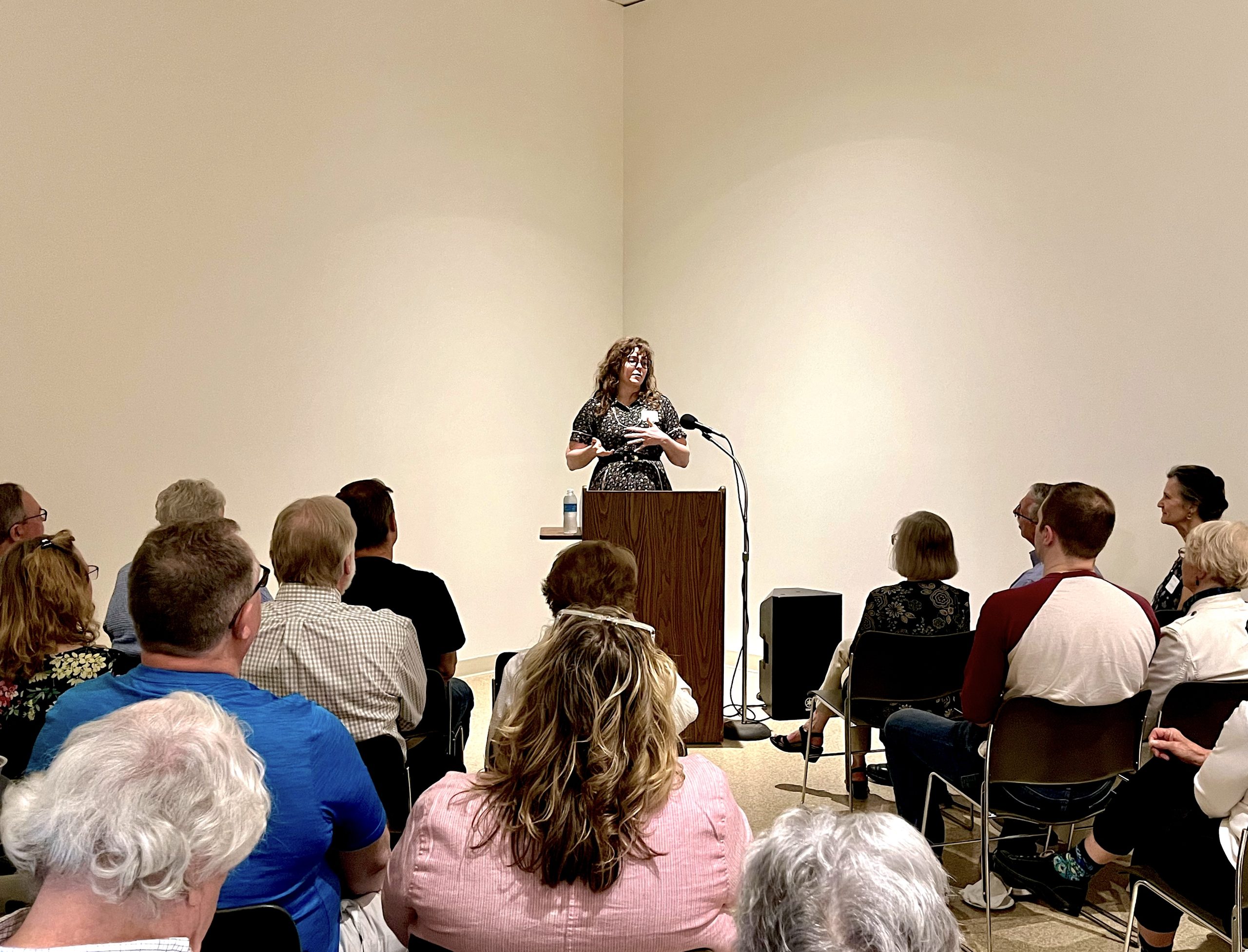 A woman standing at a podium talking in front of an audience