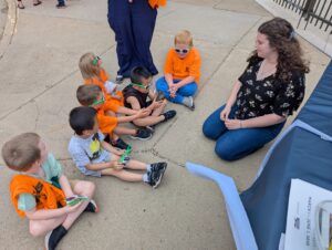 Emily sitting on the ground with students at the career event.
