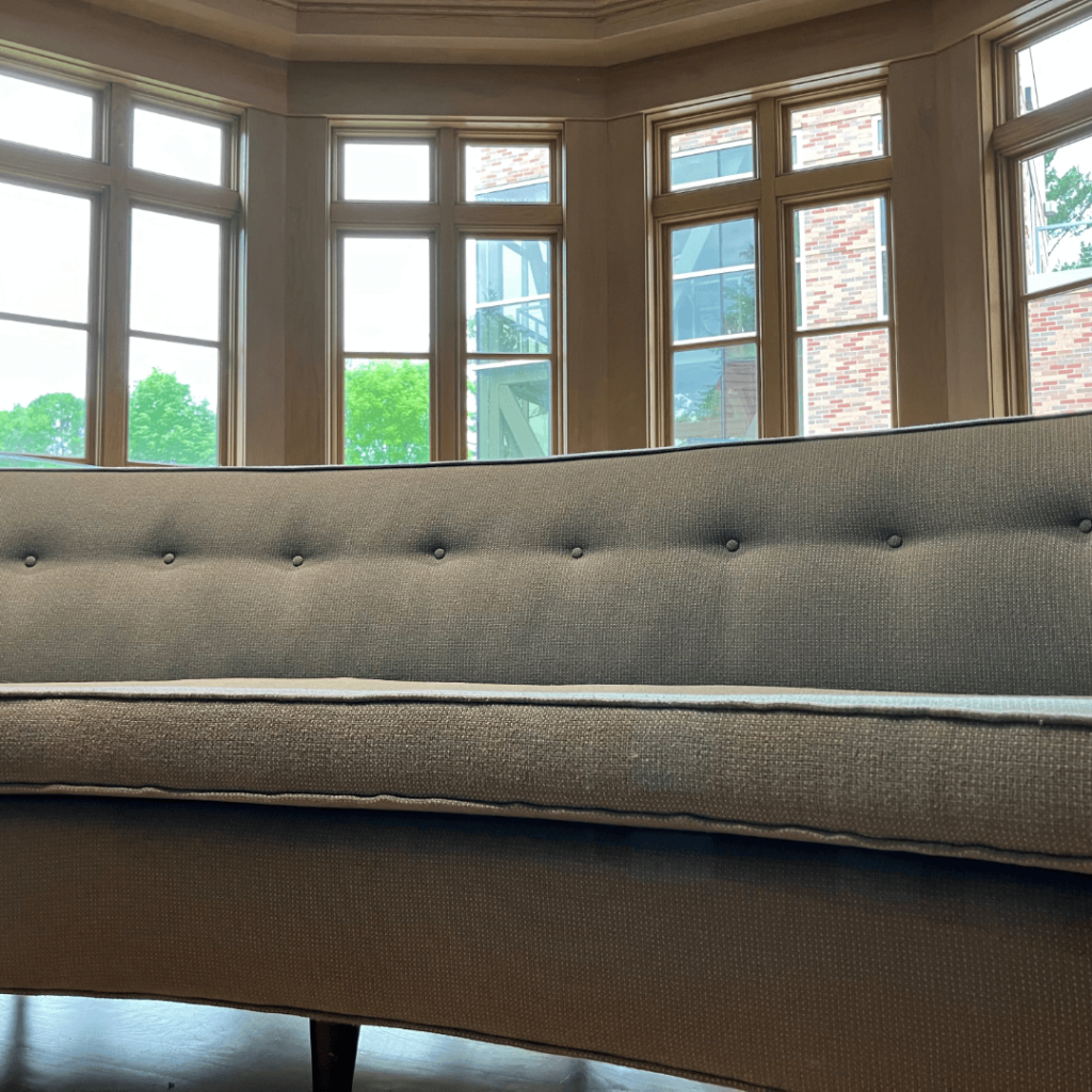 Close-up image looking up at the mint green couch as it sits near the windows in the decorative arts gallery.