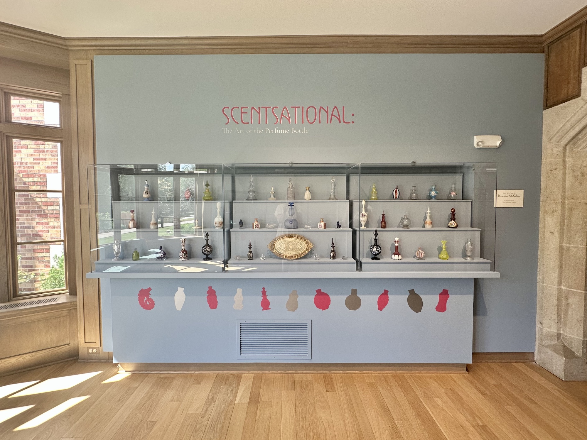 an image of a gallery wall with perfume bottles sitting on shelves.