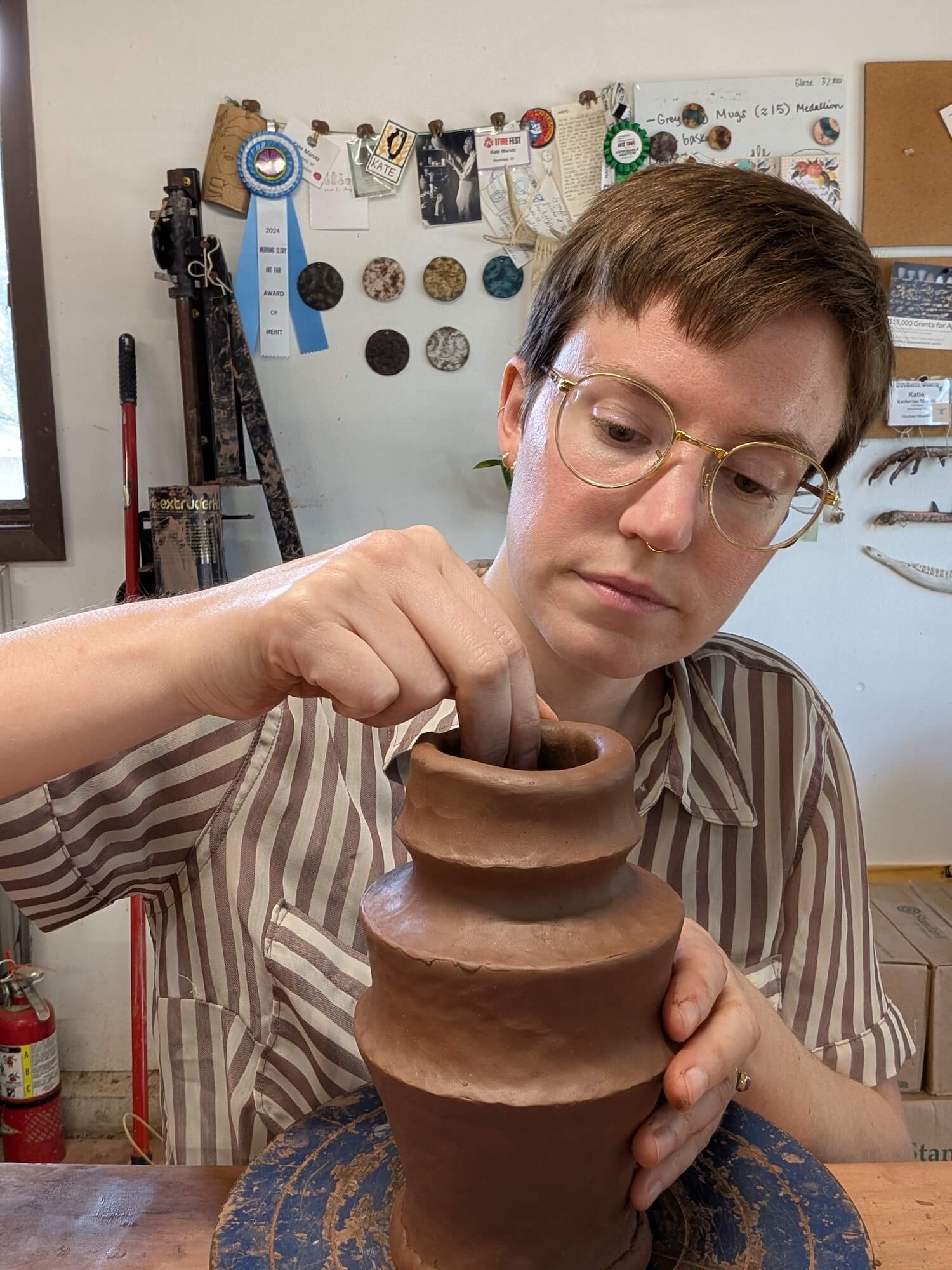 Headshot of Artist in Residence, Kate Marotz, as she works on a ceramic vase.
