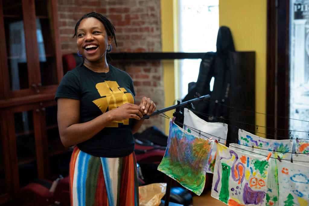 Smiling woman standings infront of artworks