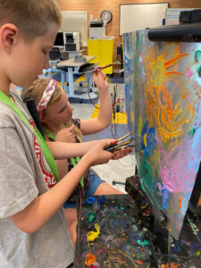 Two children paint.